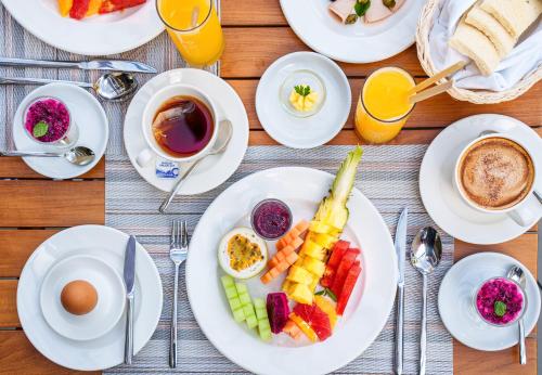 a table with plates of food and cups of coffee at Ocean's Creek Beach Hotel in Balaclava