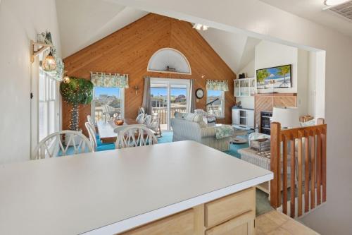 a kitchen and living room with a table and chairs at 6133 - Coastal Crave in Nags Head