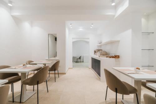 a dining room with white tables and chairs at Maison Sirolo in Sirolo