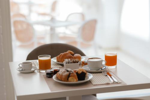 a table with two plates of food and two cups of orange juice at Maison Sirolo in Sirolo