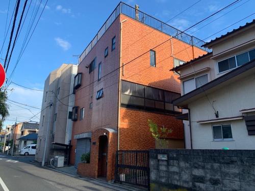 a brick building on the side of a street at 203 Private House in Tokyo Koiwa Station in Tokyo