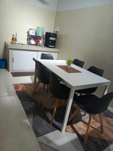 a white table and chairs in a kitchen at Sofia's Homestay - For MusLiiM in Kuantan