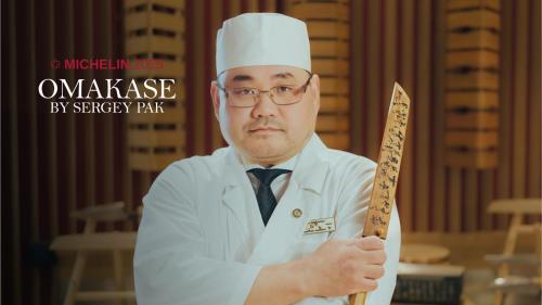 a man in a chefs hat holding a knife at Skostredet Hotel in Bergen