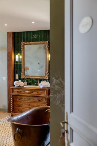 a bathroom with a tub and a dresser with a mirror at Chateau Pascalette in La Londe-les-Maures