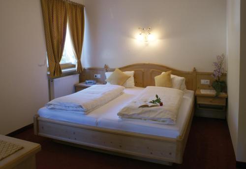Schlafzimmer mit einem Bett mit weißer Bettwäsche und einem Fenster in der Unterkunft Anna's Appartements in Pertisau