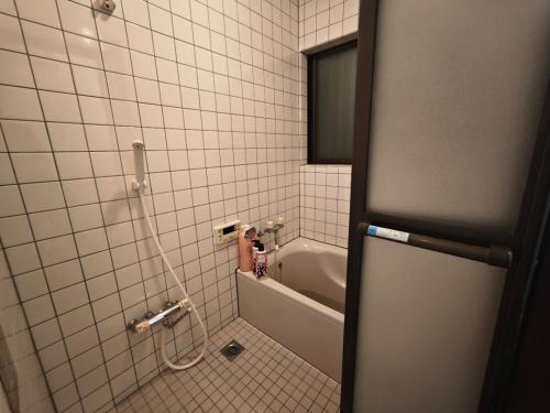 a bathroom with a bath tub and a sink at ZYZ Fujimidai House練馬一户建 in Tokyo