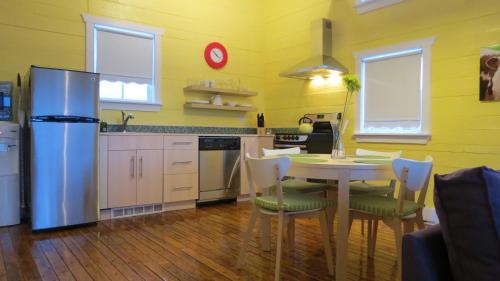 a kitchen with a table and chairs and a refrigerator at The Old Salt Box Co. - Daisy's Place in Herring Neck
