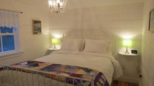 a bedroom with a bed with two lamps on both sides at The Old Salt Box Co. - Daisy's Place in Herring Neck