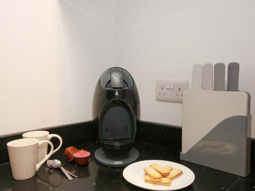 a coffee maker on a counter with a plate of bread at The Hideaway in Bishops Castle