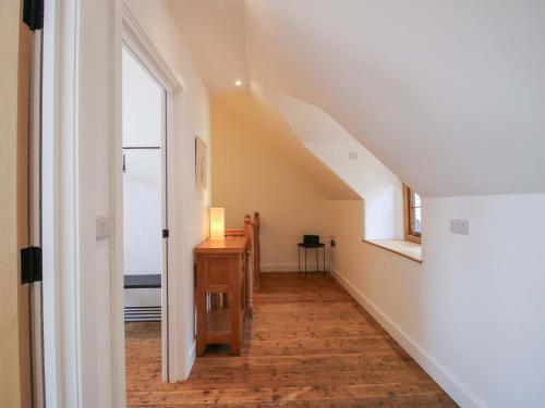 an attic hallway with a window and a wooden floor at The Hideaway in Bishops Castle