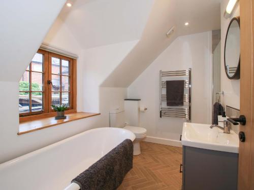 a bathroom with a tub and a toilet and a sink at The Hideaway in Bishops Castle