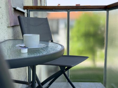 a cup sitting on a table next to a window at Becky Apartman in Komló