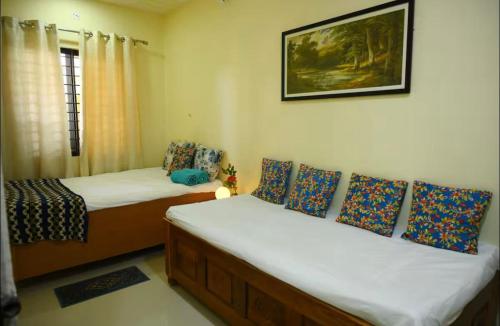 two twin beds in a room with a picture on the wall at Renuka Luxury Stay in Kishanganj Bazar