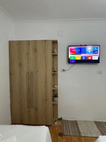 a room with a television on a wall with a bed at Meraki Room Tirana Center in Tirana