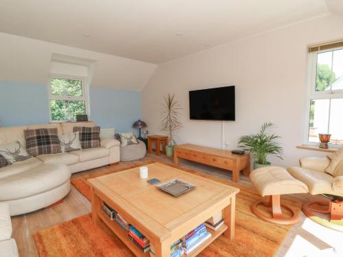 a living room with a couch and a table at 1 Bryn Beudy in Narberth