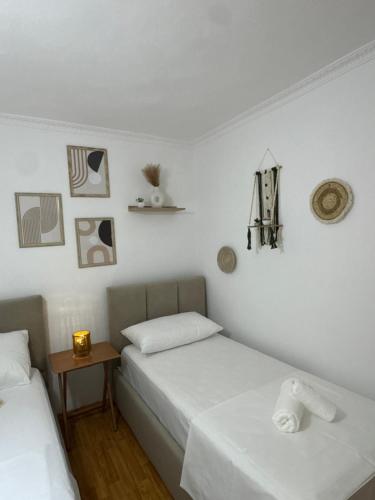 two beds in a room with white walls at Meraki Room Tirana Center in Tirana