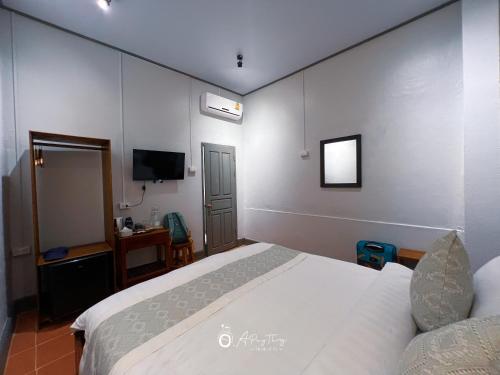 a bedroom with a white bed and a television at SamaiLaos Residence in Luang Prabang