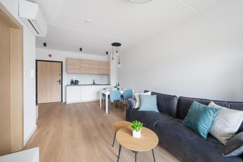 a living room and kitchen with a couch and a table at ReVital Mechelinki by Homeprime Parking Free in Mechelinki