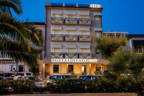a hotel building with cars parked in a parking lot at Junior Suite Hotel Biagi in Lido di Camaiore