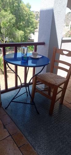 a blue table and a chair on a balcony at Aggeliki's Beach Escape Above the Sea - Northern Chios in Límnos