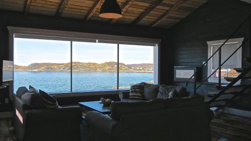 a living room with a view of the water at The Old Salt Box Co - Gertie's Place in Twillingate