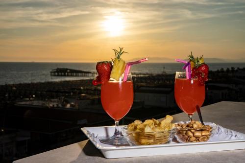 two drinks on a tray with strawberries and other snacks at Junior Suite Hotel Biagi in Lido di Camaiore