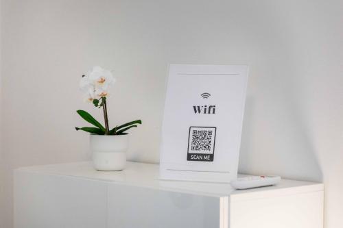 a white box sitting on a white shelf with a flower at Divi Apartments Milano - Strategic Place in Milan