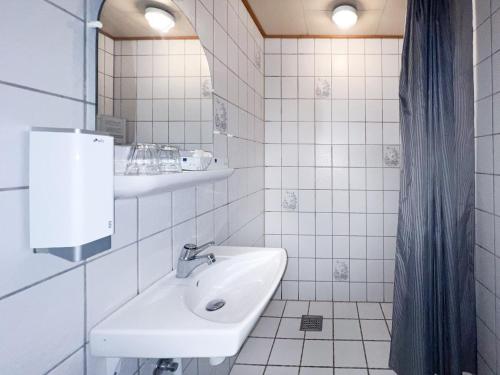 a white bathroom with a sink and a mirror at Hotel Frederikshavn in Frederikshavn