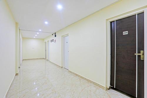 a corridor of a building with a door and a tile floor at FabHotel Sujatha Residency - Ramamurthy Naga in Bengaluru