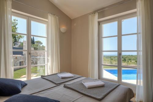 a bedroom with a bed with two towels on top of it at Villa Julia - Luxury villa with sea view in Razvala
