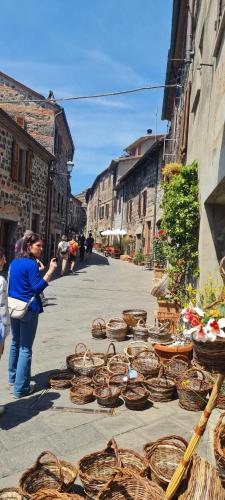 a woman taking a picture of baskets on a street at Flat Ghino di Tacco historical centre Radicofani in Radicofani