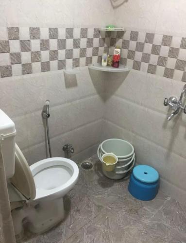 a small bathroom with a toilet and a sink at Harshita Hotel in Manāli