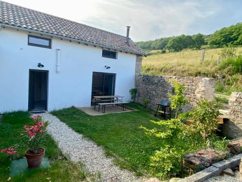 a white cottage with a picnic table in the yard at Clos Sauvage in Leynes