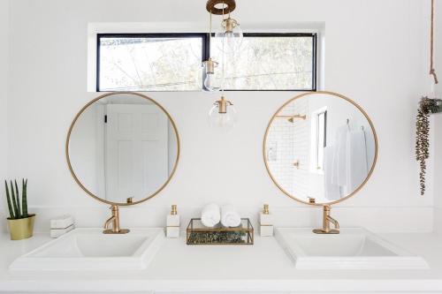 two mirrors above two sinks in a white bathroom at Silver Triangle Oasis with Verdant Backyard in Los Angeles