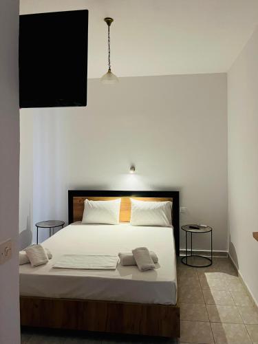a bedroom with a large white bed with two tables at Hotel Asteras in Ammoudia