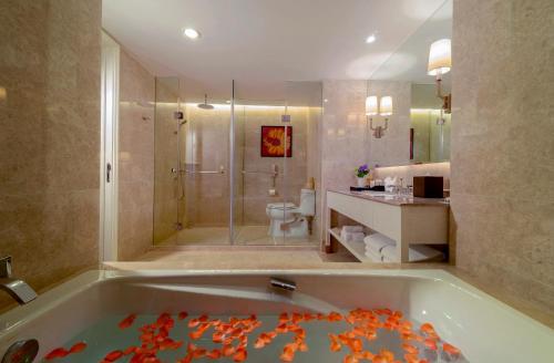 a bathroom with a tub with a shower and a toilet at Similan Hotel Zhuhai-Gongbei Port in Zhuhai