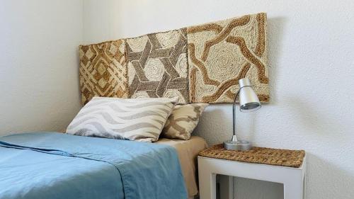 ein Schlafzimmer mit einem Bett und einem Tisch mit einer Lampe in der Unterkunft La casa del mar Nuimna in Peñíscola