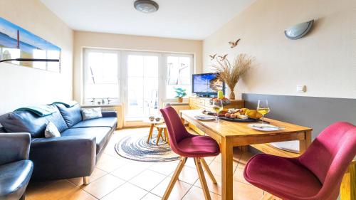 a living room with a couch and a table and chairs at Haus Seeblick mit 9 Wohnungen in Alt Reddevitz
