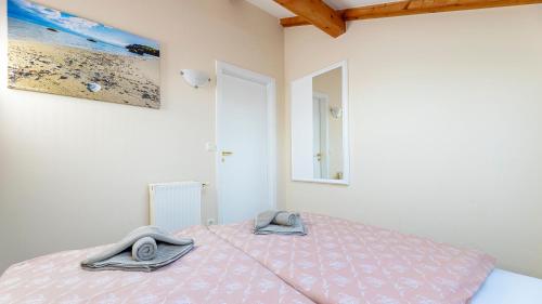 a bedroom with a bed with two towels on it at Haus Seeblick mit 9 Wohnungen in Alt Reddevitz