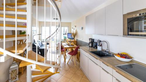 a kitchen with white cabinets and a dining room at Haus Seeblick mit 9 Wohnungen in Alt Reddevitz