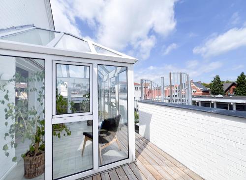 a glassconservatory on the roof of a house at Hotel Frederikshavn in Frederikshavn