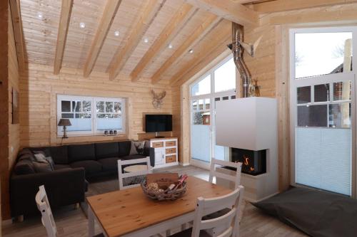 a living room with a table and a fireplace at Haus beim See in Clausthal-Zellerfeld