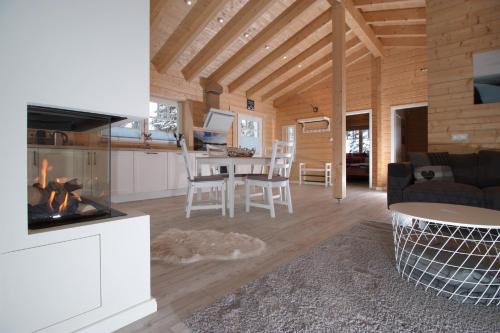 a kitchen and living room with a fireplace in a cabin at Haus beim See in Clausthal-Zellerfeld