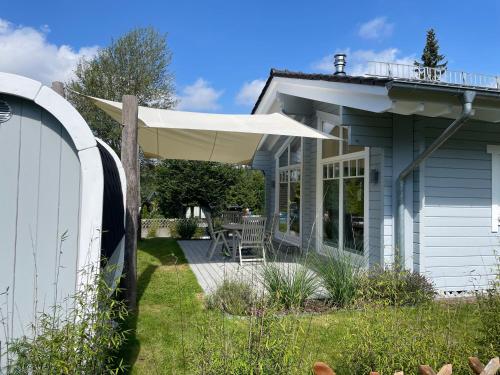 a patio with a white umbrella on a house at Haus beim See in Clausthal-Zellerfeld