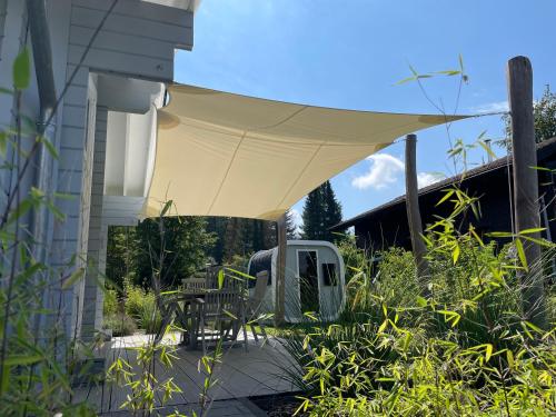 a patio with a tan umbrella on a house at Haus beim See in Clausthal-Zellerfeld