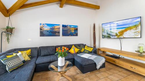 a living room with a couch and a table at Haus Seeblick mit 9 Wohnungen in Alt Reddevitz