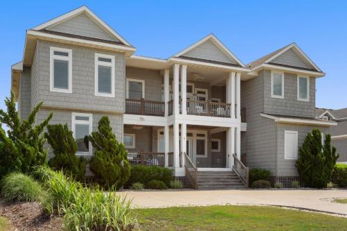 a large house with balconies and trees at 3025 - Who's On First in Southern Shores