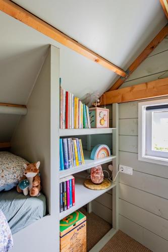 a childs bedroom with a bed and bookshelves at Boshuisje Luna | 4 personen - Vakantiepark De Kremmer in Gasselte