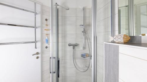 a bathroom with a shower with a glass door at Haus Seeblick mit 9 Wohnungen in Alt Reddevitz