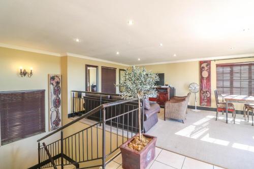 a living room with a staircase and a table at North Hill Guesthouse in Bloemfontein